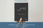 A hand holding a black lyric journal with white musical notes and the title 'LYRIC JOURNAL' on the cover, set against a light background with promotional text banners above and below.