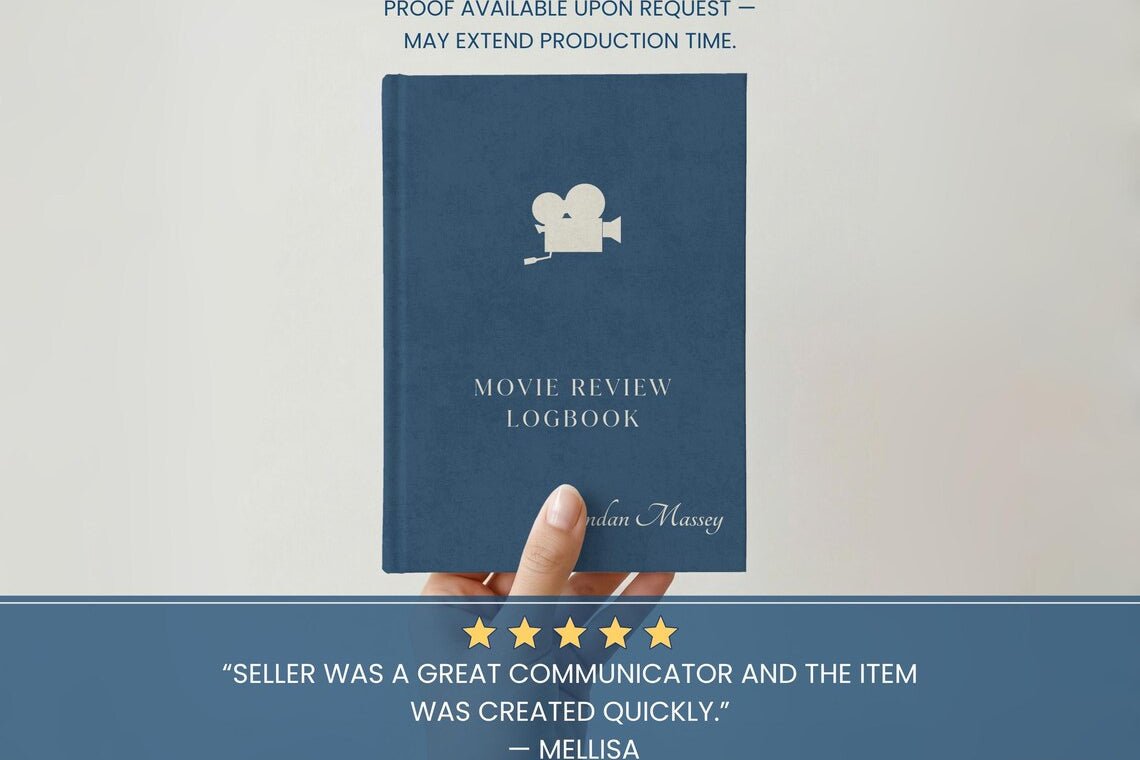 A navy blue hardcover book titled 'Movie Review Logbook' by author Melisa Massey, held by a hand against a light background. The cover features a white film camera icon and white text.
