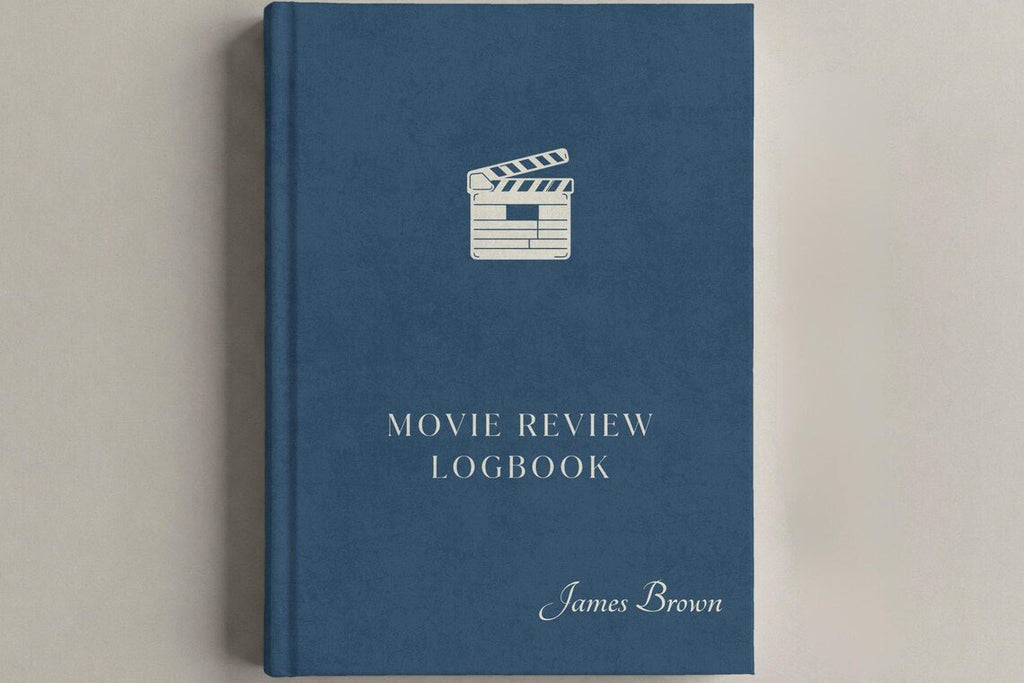 A hardcover movie review logbook in slate blue with a white clapperboard icon and white text, including the name James Brown, shown on a neutral light gray background.