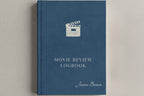 A hardcover movie review logbook in slate blue with a white clapperboard icon and white text, including the name James Brown, shown on a neutral light gray background.
